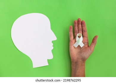 Brain Paper Cutout With Green Ribbon On Green Background With Copy Space. Mockup For World Mental Health Day