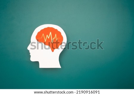 A brain shape made from paper on a green background. Awareness of Alzheimer's, Parkinson's, dementia, stroke, seizure, or mental health. Neurology and Psychology care