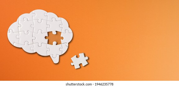 Brain shaped white jigsaw puzzle with copy space on orange background, a missing piece of the brain puzzle, mental health and problems with memory - Shutterstock ID 1946235778