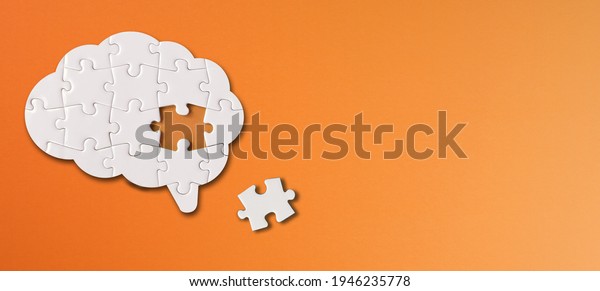 Brain shaped white jigsaw puzzle with copy space\
on orange background, a missing piece of the brain puzzle, mental\
health and problems with\
memory