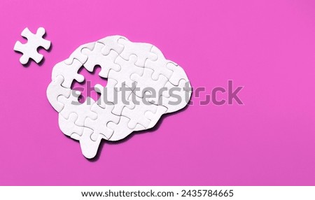 Brain-shaped puzzle with a missing element arranged on a soft pink background with copy space. Human mind complexity concept.
