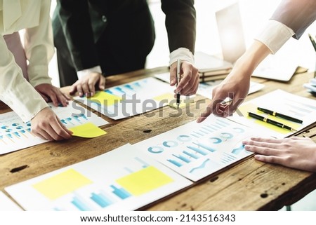 Brainstorming, Consulting, Data Analysis, Planning, Marketing and Accounting, Economist holding pen pointing to investment documents with partners on profit taking to compete with other companies.