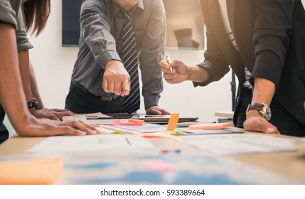 Brainstorming Group of people Working Concept. Business team brainstorming. Marketing plan researching. Paperwork on the table, laptop and mobile phone. - Shutterstock ID 593389664