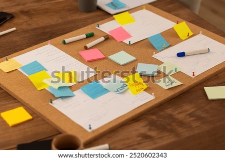 Brainstorming ideas, using sticky notes and markers on corkboard in office, start up business. teamwork, creativity, collaboration, organization, planning, workspace