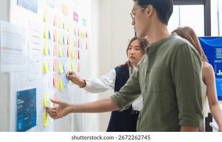 brainstorming session, using sticky notes on a task board (kanban) to organize ideas and workflow in a modern office