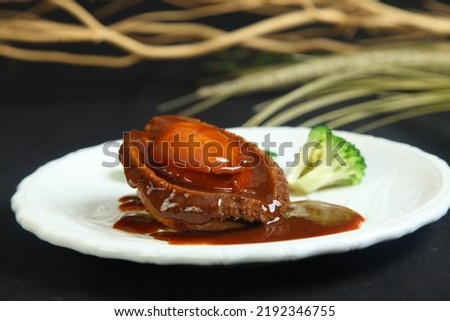 Braised abalone with broccoli and bean curd, premium expensive Chinese delicacy served during dinner celebrations