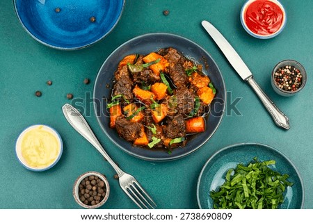 Braised beef cubes with soft sweet potatoes in thick sauce. Top view.