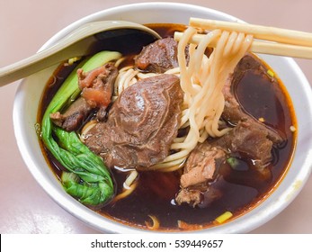 Braised Beef Noodle Soup With Chopsticks And Spoon Close-up.