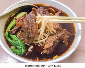 Braised Beef Noodle Soup With Chopsticks And Spoon Close-up.