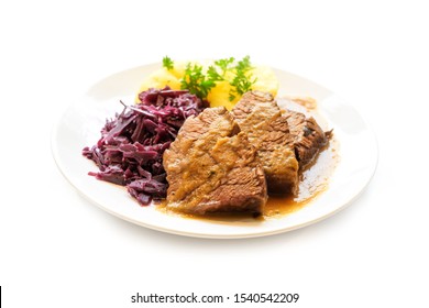 Braised Beef With Potatoes, Red Cabbage And Parsley Garnish On A Plate, Isolated On A White Background, Selected Focus, Very Narrow Depth Of Field