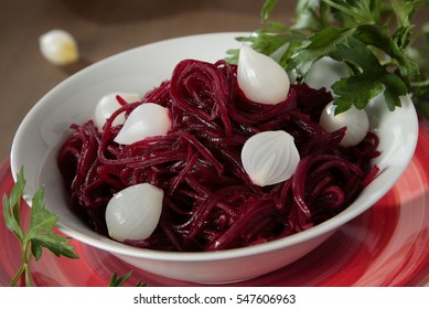 Braised beets with small pickled onions and parsley in a bowl