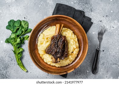 Braised Lamb Shank On The Mashed Potato In A Plate. Gray Background. Top View.