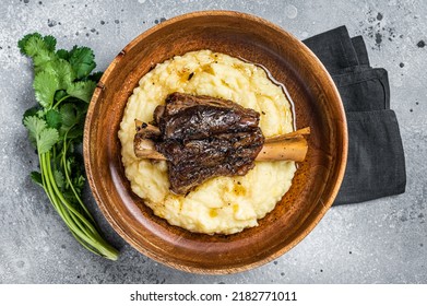 Braised Lamb Shank On The Mashed Potato In A Plate. Gray Background. Top View.