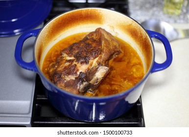 Braised Pork Roast Cooked In A Dutch Oven Resting On The Stove Top.