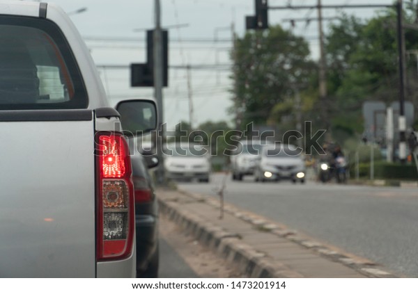 Brake cars on asphalt roads during rush hours for\
travel or business work. And the car parked on the opposite traffic\
signal.