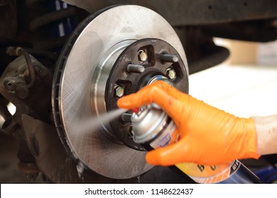 Brake Cleaner Being Applied To New Brake Rotors. Brake Pad And Rotor Replacement On 2001 Pickup Truck. Do It Yourself Brake Replacement