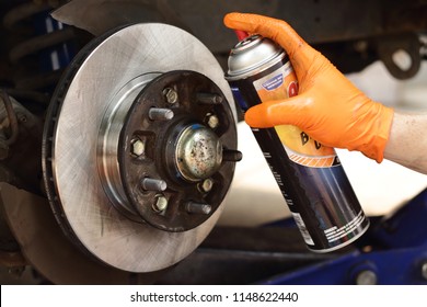 Brake Cleaner Being Applied To New Brake Rotors. Brake Pad And Rotor Replacement On 2001 Pickup Truck. Do It Yourself Brake Replacement