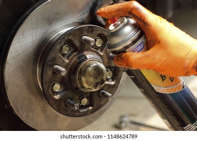 Brake Cleaner Being Sprayed On New Rotor. New Brake Rotor And Brake Pads Being Installed On A 2001pickup Truck. Neutral Color Scheme. Important For Safe Travels. Do It Yourself Brake Repair. 