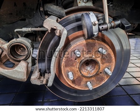 brake disc and dial gauge on car in a garage. Auto mechanic repairing a car free image