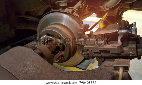 Brake disc\
grinding machine - Vehicle brake-disc turning machine. Automobile\
disc brake system repair in\
garage.