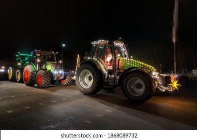 Brake, Germany - December 05, 2020: Advent convoy of farmers with festively illuminated tractors at night