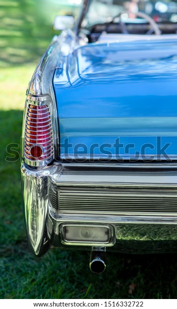 brake light of a blue vintage car, bumper of retro\
automobile, tail lights of blue convertible with windshield and\
steering wheel