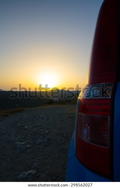 Brake\
lights of the car against the sunset and\
hills