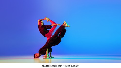 Brakedancing. Two Young People,man And Woman Dancing Contemporary Dance Over Blue Background In Neon Light. Flyer. Youth Culture, Modern Dance Aesthetics Concept