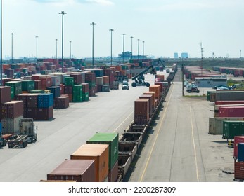 Brampton, ON, Canada - August 29, 2022: An Aerial Photo Above A Shipping Terminal While A Freight Train Is Seen Stopped In The Terminal, Being Loaded In With Shipping Containers During The Day.