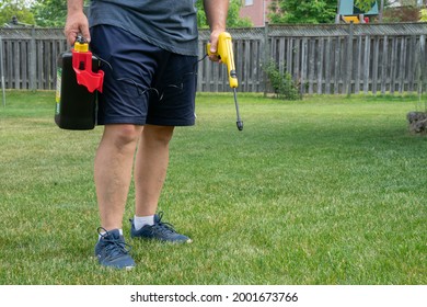 Brampton, ON Canada - June 7 2021: Caucasian man spraying and using Spectracide Accushot Weed Stop Killer For Lawns on grass in the sun during summer.