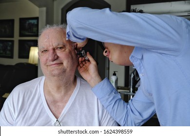 BRAMPTON, ONTARIO /CANADA - JANUARY 23 2020: Doctor Or Technician Removing Ear Wax From Senior Male