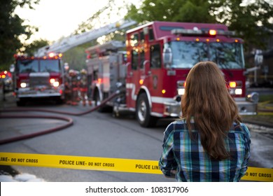 BRAMPTON, ONTARIO -  JULY 20 2012 - Teen Girl Stands Behind Police Tape Watching A House Fire At 20 Esker Drive In Brampton Ontario On July 20, 2012