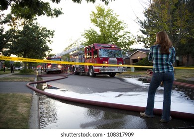 BRAMPTON, ONTARIO -  JULY 20 2012 - Teen Girl Stands Behind Police Tape Watching A House Fire At 20 Esker Drive In Brampton Ontario On July 20, 2012