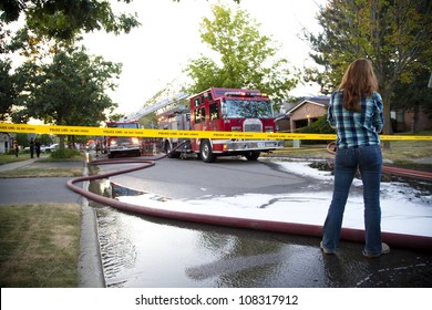 BRAMPTON, ONTARIO -  JULY 20 2012 - Teen Girl Stands Behind Police Tape Watching A House Fire At 20 Esker Drive In Brampton Ontario On July 20, 2012