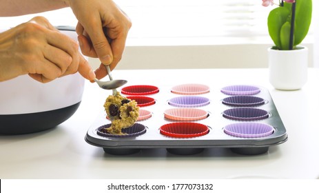 Bran Muffins With Dry Cranberries Recipe. Filling Silicone Cups With Muffin Batter Close Up On White Background