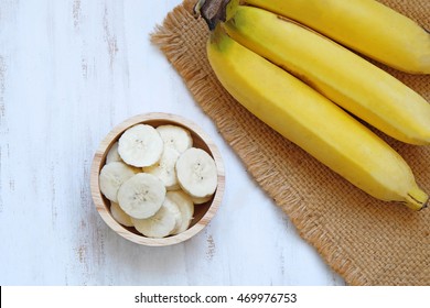 A Branch Of Bananas And A Sliced Banana In A Bowl