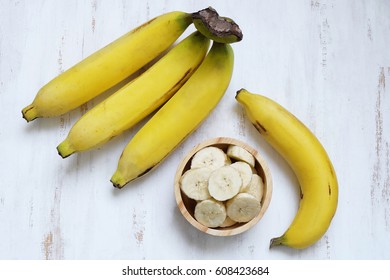 A Branch Of Bananas And A Sliced Banana In A Bowl.