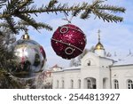 A branch of a Christmas tree with decorations on the background of an Orthodox cross with a crucifix. Orthodox Church. Winter - Christmas, New Year. The concept of Orthodoxy.