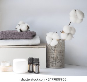 A branch of cotton flowers in a vase, cotton towels, aroma oils, natural soap on a white, light gray background. Place for text, postcard, background, copy - Powered by Shutterstock