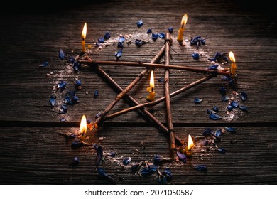 Branch Pentagram - Witchcraft Tools Of Natural Wood. Wooden Pentagram With Candles, Small Stones And Petals Of Delphinium. Occultism And Mysticism.