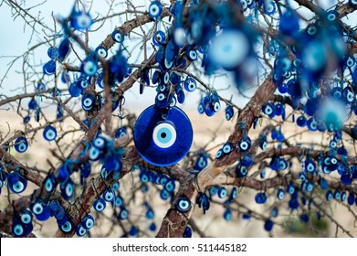 The Branches Of The Old Tree Decorated With The Eye-shaped Amulets - Nazars, Made Of Blue Glass And Believed To Protect Against The Evil Eye In Goreme National Park, Cappadocia, Turkey.