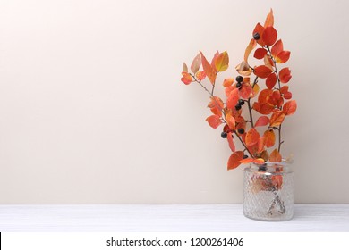 Branches with red leaves in vase in interior in autumn time.  Background with colorful branches bouquet and empty place.

 - Powered by Shutterstock