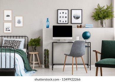 Branches Of Spruce In Glass Vases In Classy Bedroom And Workspace For Teenager, Real Photo With Posters On Empty Grey Wall