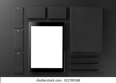 Brand identity mockup. Blank corporate stationery and gadgets set at black textured paper background.