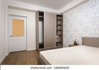 Brand New Almost Empty Beige Bedroom With Bare Mattress At Twin Bed, Bedside Tables And Open Closet