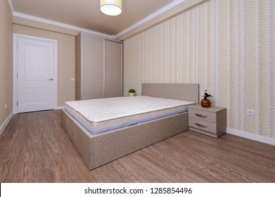 Brand New Almost Empty Brown Bedroom With Bare Mattress At Twin Bed And Bedside Tables