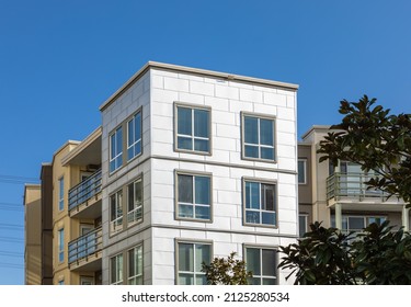 Brand new apartment building on sunny day in BC, Canada. Canadian modern residential architecture. Nobody, street photo