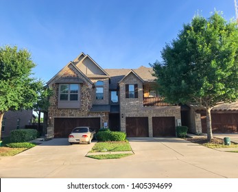 Brand New Attached Houses Townhome Style With Double Wooden Garage Doors, Small Front Yard. Townhouse Units In Suburban Dallas, Texas, USA. Front View Facade Of Two Stories House Nice Trim Landscape