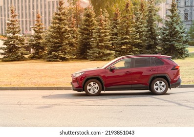 Brand New Dark Red Suv Toyota Hybrid Driving On The Street In Sunlight In City. Riga, Latvia, 08.24.2022