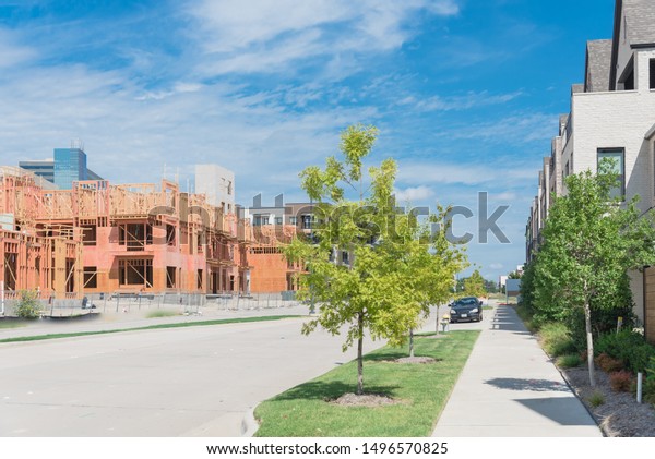 Brand new development community in North Dallas,\
Texas, USA with mixed of single family detached residential houses\
and upscale multistory apartment building complex under\
construction, clean\
sidewalk